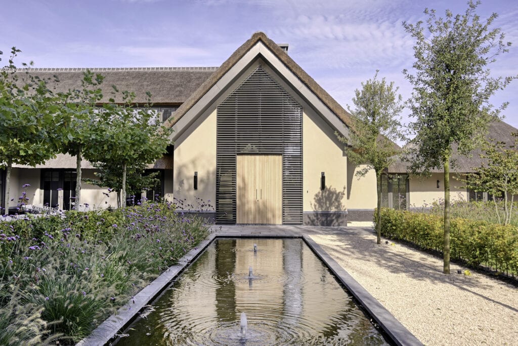 Landelijke villa met kantelbare lamellen in een puntraam om en rond de voordeur