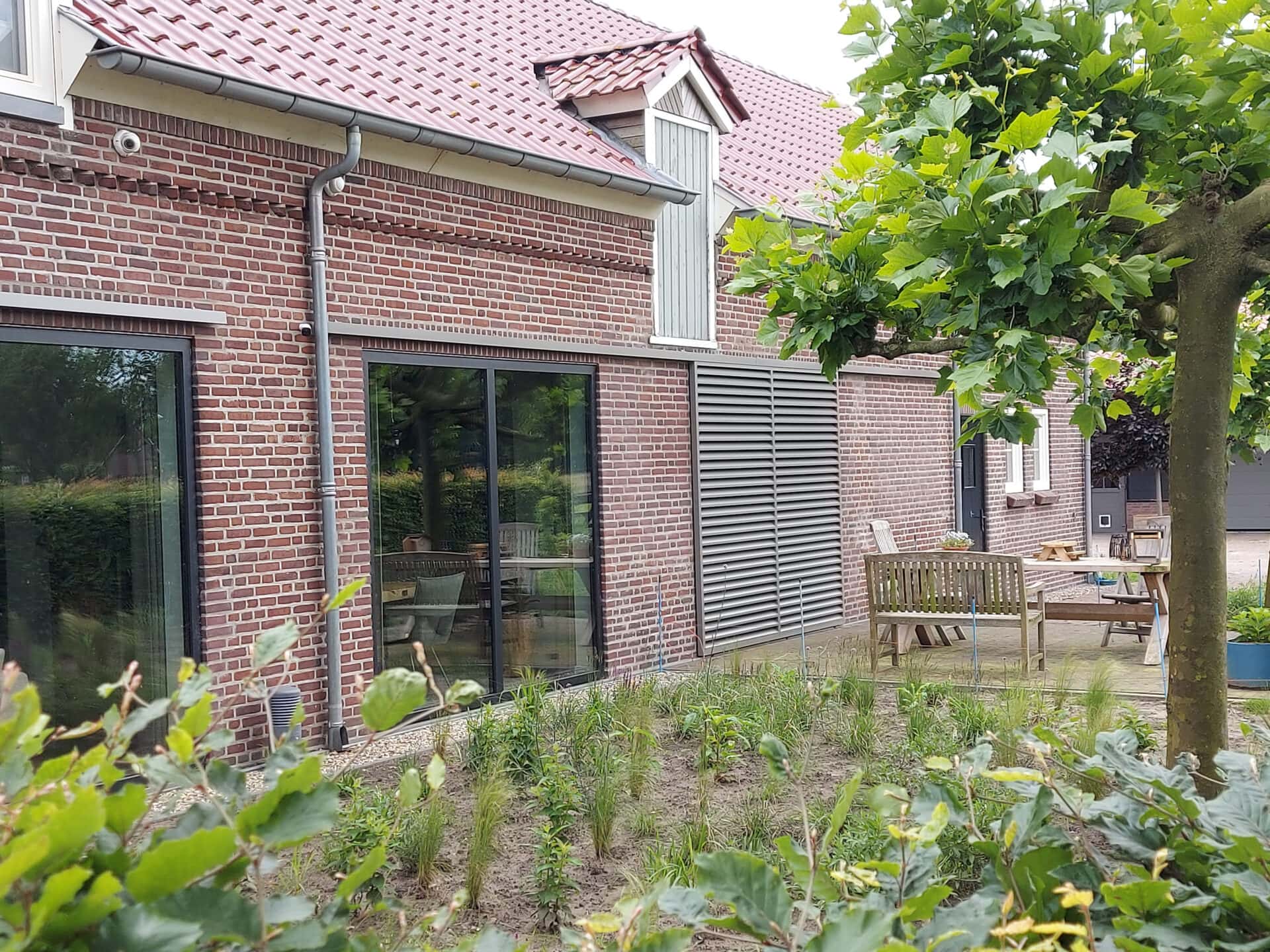 Klassieke woning met schuifpanelen met vaste lamellen aan de gevel, voor het raam