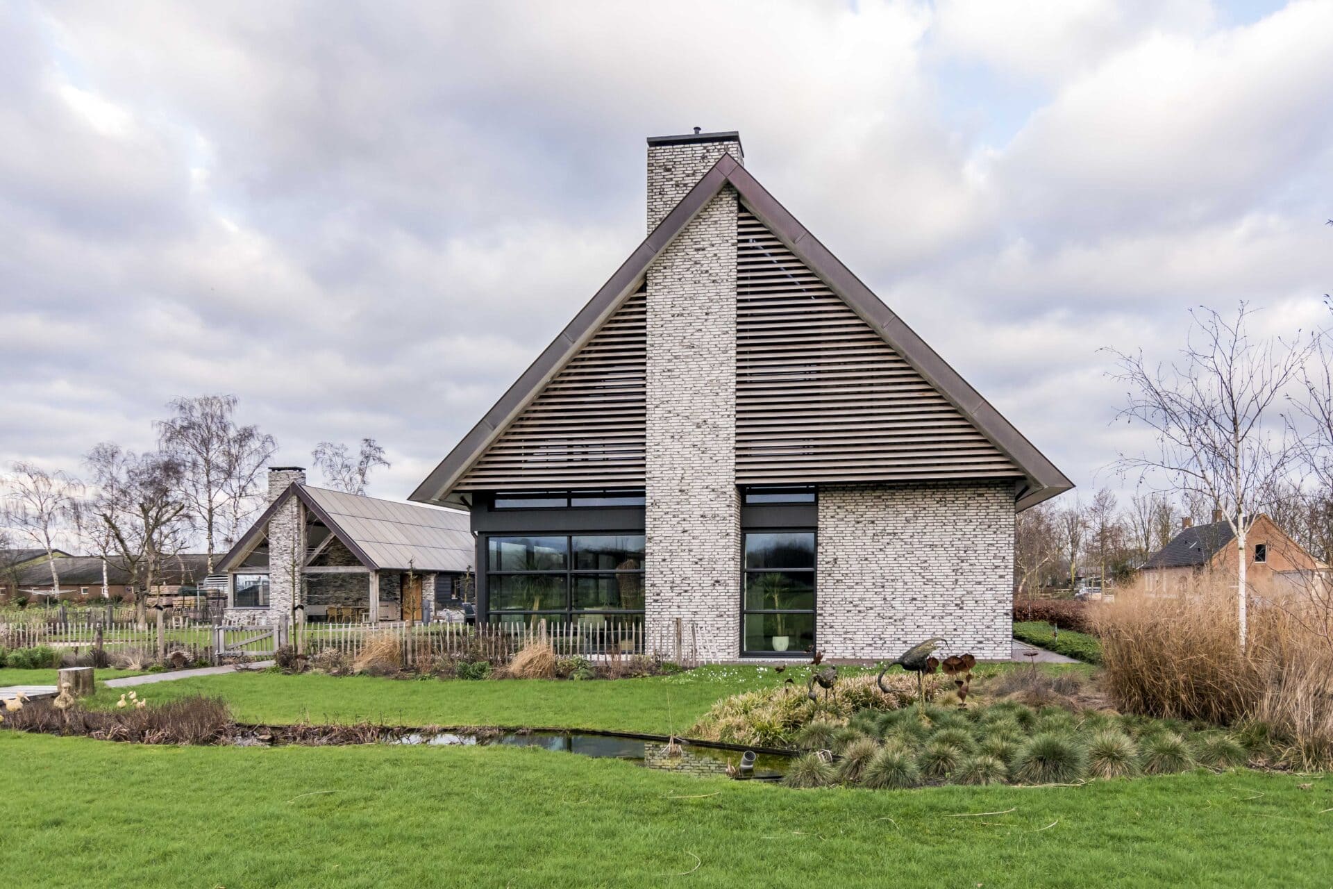 Landelijke woning met houten lamellen in driehoek