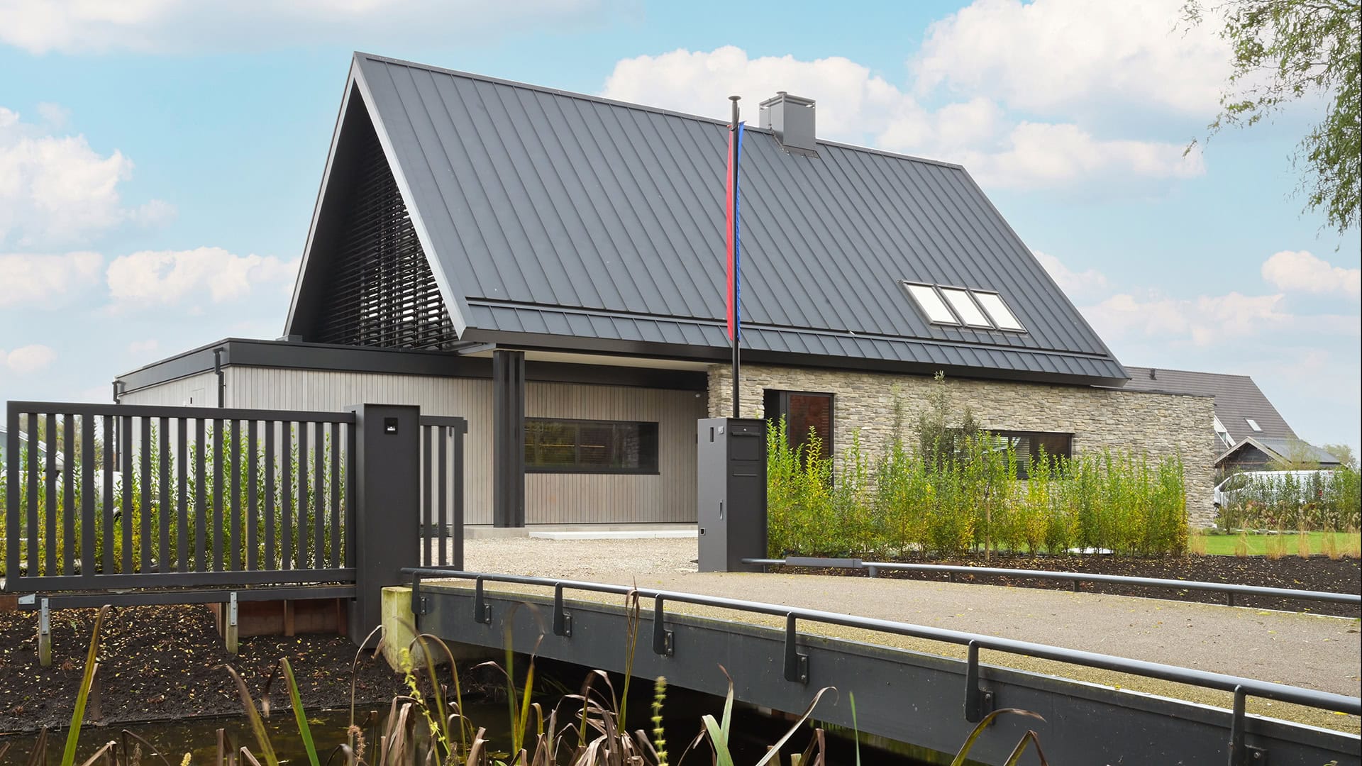 Zijaanzicht van de woning met kantelbare lamellen in de puntgevel