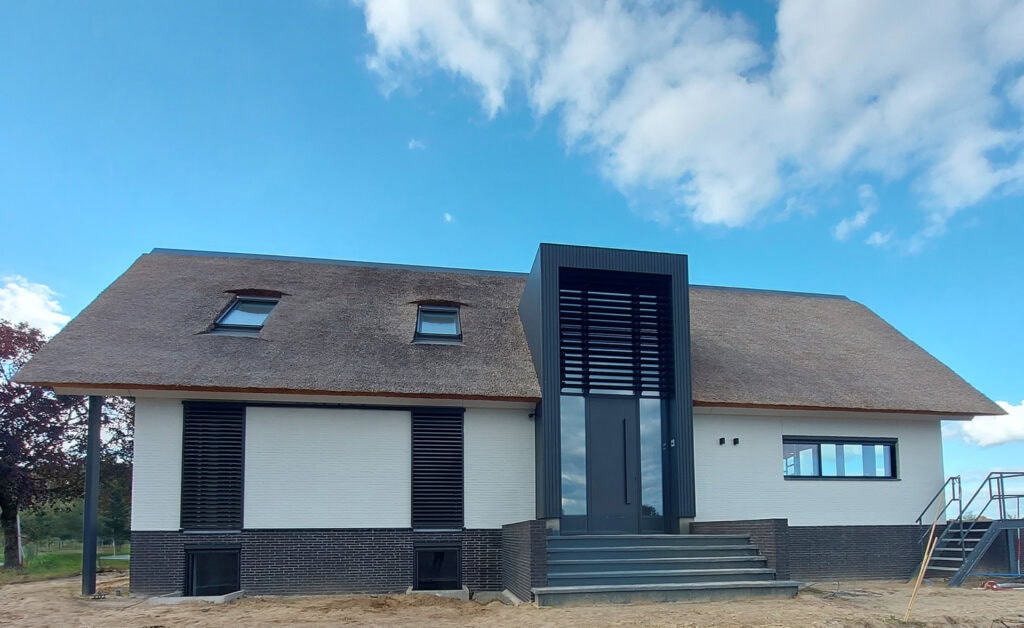 Moderne woonboerderij met kantelbare lamellen in een risaliet